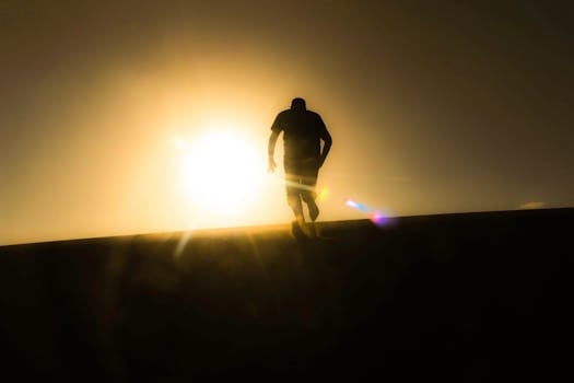 Silhouette of a man running uphill against a bright desert sunrise, capturing a sense of solitude and determination.